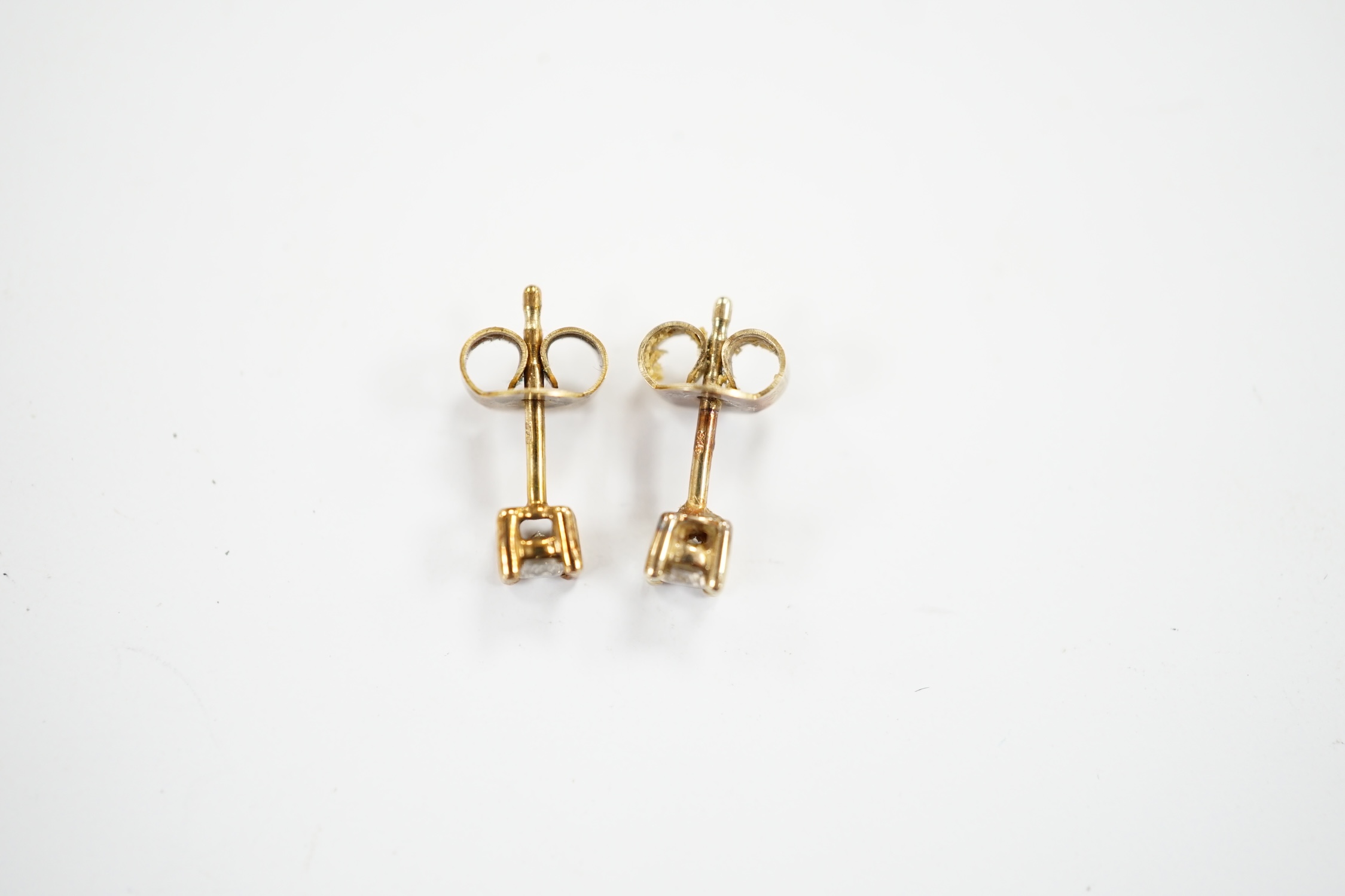 A small pair of 375 and solitaire diamond set ear studs, gross weight 0.8 grams.